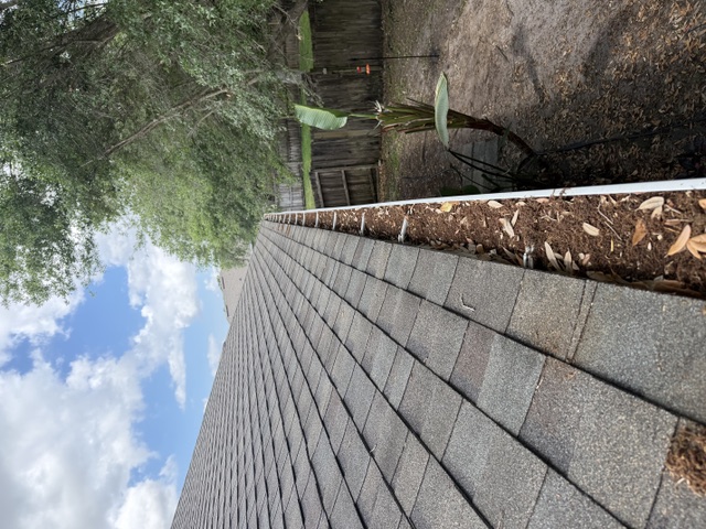 Same roof-edge gutter with the channel clear after debris removal