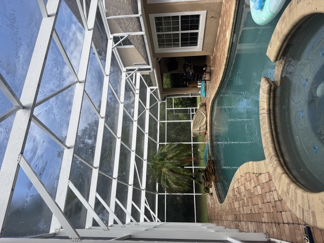 Bright clean pool enclosure beams and screens above the pool after cleaning